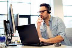 young-beautiful-male-call-center-operator-working-his-computer-his-headset-young-male-call-center-operator-working-132123125
